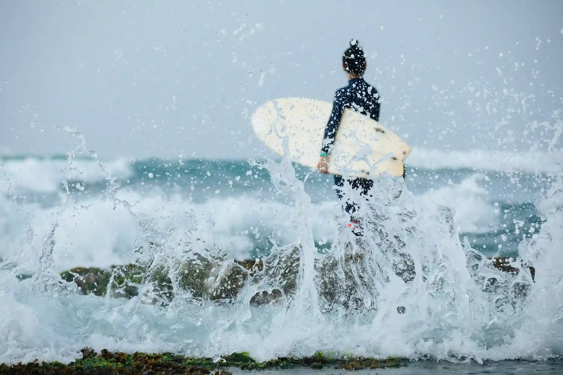 Surfer walking toward the ocean